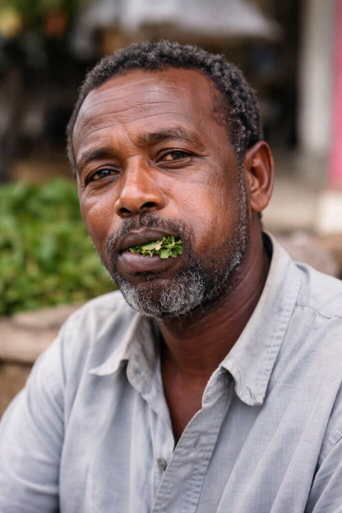homme mange du khat avec formation d' une boule sur la joue